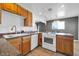 This kitchen features wood cabinets, tile floors, a white range, and plenty of counter space at 2940 W Townley Ave, Phoenix, AZ 85051