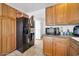 Updated kitchen with black refrigerator, tile floor, and lots of wood cabinet storage at 2940 W Townley Ave, Phoenix, AZ 85051