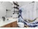 Charming bathroom with a vintage-style vanity, decorative shower curtain, and open shelving at 3426 E Elgin St, Gilbert, AZ 85295