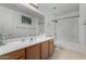 Bright bathroom with a large mirror, dual sinks, tile flooring and a shower-tub combo at 3426 E Elgin St, Gilbert, AZ 85295
