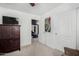 A carpeted bedroom featuring a television atop a wooden dresser, a closet, and access to a living room at 3426 E Elgin St, Gilbert, AZ 85295