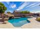 Backyard pool with a rock waterfall feature, surrounded by landscaping and a patio at 3426 E Elgin St, Gilbert, AZ 85295
