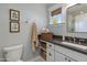 Bathroom with a white vanity, dark countertop, and a framed botanical wall decor at 3727 E Highland Ave, Phoenix, AZ 85018