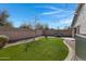 Backyard featuring artificial turf, a cozy seating area, and charming string lights at 4091 S Dew Drop Ct, Gilbert, AZ 85297