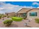 The backyard features a synthetic putting green, covered patio, desert landscaping, and outdoor seating at 41553 W Springtime Rd, Maricopa, AZ 85138