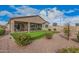 A landscaped backyard with a synthetic putting green, desert landscaping, and covered patio seating area at 41553 W Springtime Rd, Maricopa, AZ 85138