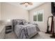 Comfortable bedroom featuring a large window, ceiling fan, and stylish furnishings at 41553 W Springtime Rd, Maricopa, AZ 85138