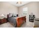 Comfortable bedroom with a reading chair and stylish lamp with natural light from a window at 41553 W Springtime Rd, Maricopa, AZ 85138