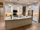 Bright kitchen features granite counters, a stainless steel refrigerator, and a large center island with pendant lighting at 41553 W Springtime Rd, Maricopa, AZ 85138