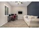 Bright living space with wood-look tile flooring, a ceiling fan, and a large sofa for comfortable lounging at 41553 W Springtime Rd, Maricopa, AZ 85138