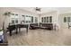 Bright and spacious living area with tile floors, a baby grand piano, and stylish leather sofa under a modern ceiling fan at 41553 W Springtime Rd, Maricopa, AZ 85138