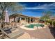 Outdoor kitchen with a built-in grill, pool, and spacious seating area, perfect for entertaining at 42211 N Long Cove Way, Anthem, AZ 85086