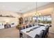 Open-concept dining area with large windows offering views of an outdoor fireplace and mountains at 42211 N Long Cove Way, Anthem, AZ 85086