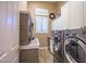 A tidy laundry room with gray cabinets, countertops, and modern washer and dryer at 42211 N Long Cove Way, Anthem, AZ 85086