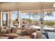 Bright living room with a comfortable sofa and large windows showcasing outdoor fireplace and views at 42211 N Long Cove Way, Anthem, AZ 85086