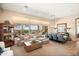 Spacious living room featuring large windows with backyard views and adjacent dining area at 42211 N Long Cove Way, Anthem, AZ 85086