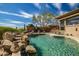 Sparkling private pool with a rock waterfall feature and lush landscaping at 42211 N Long Cove Way, Anthem, AZ 85086