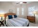 Bedroom with a wicker headboard, blue and white bedding, and two windows with plantation shutters at 6202 E Mckellips Rd # 171, Mesa, AZ 85215