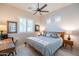 Bedroom with a wood bed frame, ceiling fan, and a window with plantation shutters at 6202 E Mckellips Rd # 171, Mesa, AZ 85215