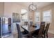 Dining area with a wood table, six chairs, globe chandelier, wine fridge, and a view to the kitchen at 6202 E Mckellips Rd # 171, Mesa, AZ 85215