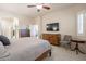 Primary bedroom featuring a wood bed, television, ensuite bathroom, and closet space at 6202 E Mckellips Rd # 171, Mesa, AZ 85215