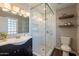 Bright bathroom featuring a glass shower, patterned tile floor and floating wood shelves at 6414 W Monterey Pl, Chandler, AZ 85226