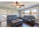 Bright living room with large windows, sliding glass doors and comfortable gray sofas at 6414 W Monterey Pl, Chandler, AZ 85226