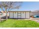 Charming backyard shed with painted trim, surrounded by lush greenery and a well-maintained lawn at 6414 W Monterey Pl, Chandler, AZ 85226