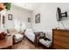 A cozy bedroom with natural light, an armchair, a ceiling fan, and wood-look flooring at 6456 E Orion St, Mesa, AZ 85215