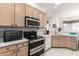 Functional kitchen featuring modern appliances, light wood cabinets, and white countertops at 6456 E Orion St, Mesa, AZ 85215