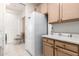 Bright laundry room featuring a large white refrigerator, tile floors, and adjacent storage cabinets at 6456 E Orion St, Mesa, AZ 85215