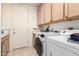 Well-equipped laundry room with front-load washer, dryer, sink, and ample cabinet storage space at 6456 E Orion St, Mesa, AZ 85215