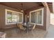 Inviting covered patio with ceiling fan, dining set, and views of the backyard landscaping at 6456 E Orion St, Mesa, AZ 85215
