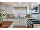 Bright kitchen features white cabinets, stainless steel appliances, and a window offering a view to the backyard at 7226 E Virginia Ave, Scottsdale, AZ 85257