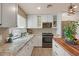 Updated kitchen with white cabinets, stone countertops, stainless steel appliances, and stylish pendant lighting at 7226 E Virginia Ave, Scottsdale, AZ 85257