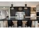 Modern kitchen features an island with seating, marble countertops, and unique lighting fixtures at 8541 N Farview Dr, Scottsdale, AZ 85258