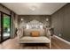 Spacious main bedroom with a decorative headboard, bench, and light fixture, plus access to the outdoors at 8541 N Farview Dr, Scottsdale, AZ 85258