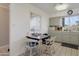 Bright kitchen with white cabinets, tile countertops, and a dining area perfect for casual meals at 10408 N 105Th Ave, Sun City, AZ 85351