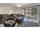 Bright living room boasts a plush gray sofa, a comfortable leather recliner, and a sliding glass door at 10408 N 105Th Ave, Sun City, AZ 85351