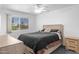 Main bedroom with wood-look furnishings, ceiling fan and large window at 10408 N 105Th Ave, Sun City, AZ 85351