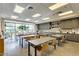 A community activity room includes tables, chairs, cabinets, and natural light at 10726 E Tallahassee Ave, Mesa, AZ 85212