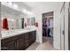 Bathroom featuring a double sink vanity with sleek fixtures, walk-in closet, and glass shower at 10726 E Tallahassee Ave, Mesa, AZ 85212