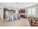Open concept kitchen featuring a central island with seating, stainless appliances, and seamlessly connects to the living area at 10726 E Tallahassee Ave, Mesa, AZ 85212