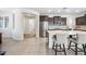 Bright kitchen with stainless steel appliances, a stylish island with seating, and seamless flow into the adjacent hallways at 10726 E Tallahassee Ave, Mesa, AZ 85212