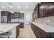 Spacious kitchen with stainless appliances, dark wood cabinetry, white quartz countertops, and tile backsplash at 10726 E Tallahassee Ave, Mesa, AZ 85212