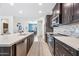 Modern kitchen with stainless appliances, dark cabinets, island seating and open access to the dining room at 10726 E Tallahassee Ave, Mesa, AZ 85212