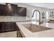 Bright kitchen with a stainless steel faucet, quartz counters, dark cabinets, and decorative tile backsplash at 10726 E Tallahassee Ave, Mesa, AZ 85212