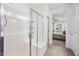 Bright bathroom featuring a glass shower enclosure with a built-in bench and a view into the bedroom at 10726 E Tallahassee Ave, Mesa, AZ 85212