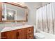 Bright bathroom with a decorative mirror, cabinet storage, and a shower-tub combination at 11406 W Piccadilly Rd, Avondale, AZ 85392