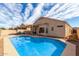 Back exterior view with a pool, covered patio, and well-maintained landscaping at 11406 W Piccadilly Rd, Avondale, AZ 85392